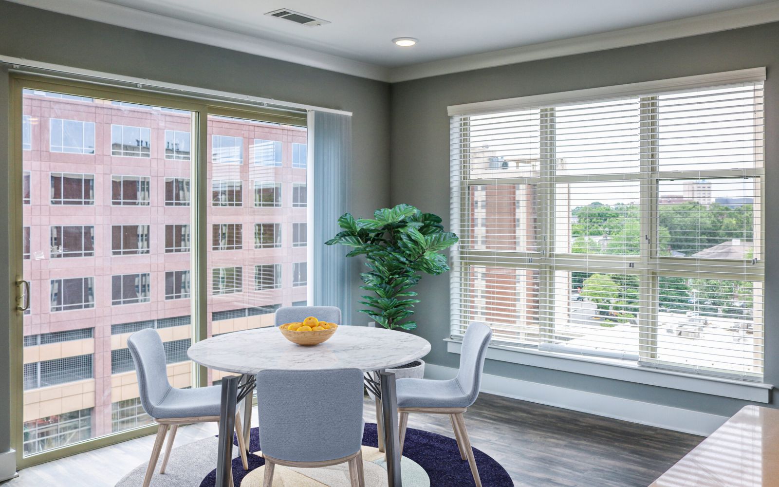 Modern dining area with round table and city view—perfect for your first college apartment at Carolina Square.