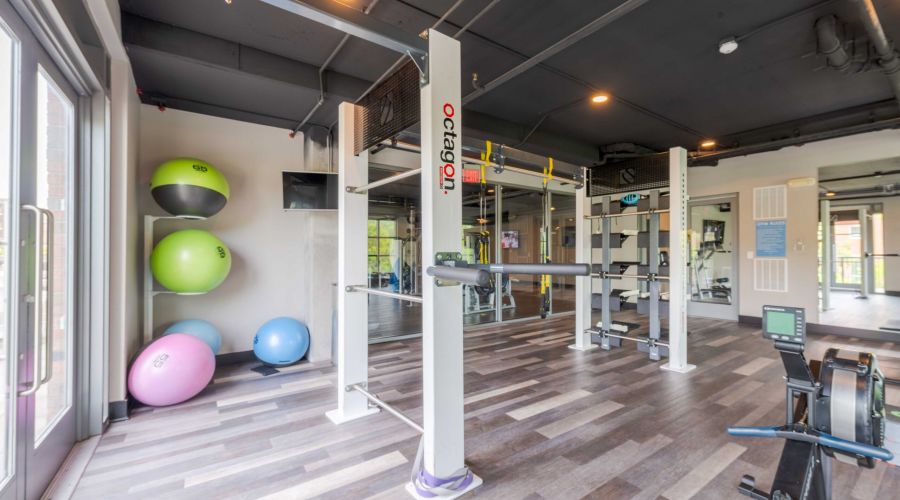 Modern gym at Carolina Square with diverse equipment and stability balls—perfect for your wellness weekend in a bright, airy space.