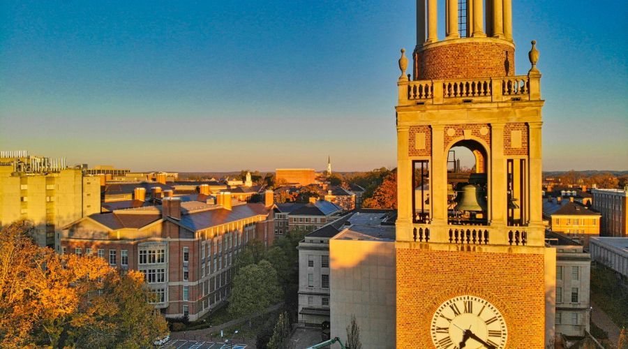 Bell tower with a clock at sunset, overlooking campus and trees, near Downtown Chapel Hill dining and vibrant Chapel Hill restaurants.