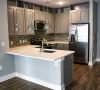 Modern kitchen with gray cabinets, stainless steel appliances, pendant lights, and a white island at Carolina Square apartments