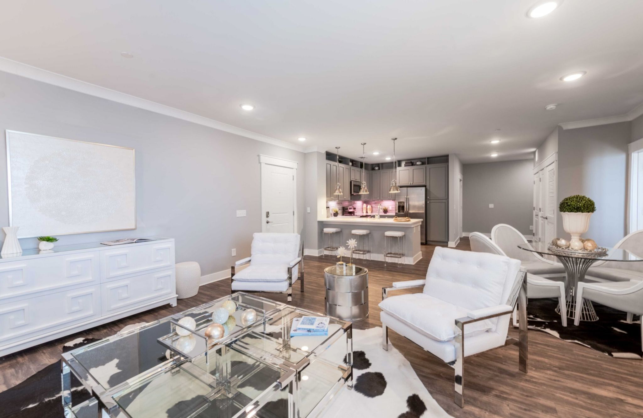 Beautiful apartment living and kitchen area with luxury hard-wood plan flooring, sliding barn doors, and huge windows