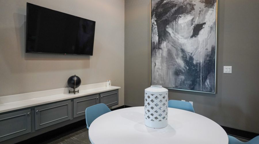 Round table with blue chairs, modern decor, and abstract art—perfect for a student home near UNC-Chapel Hill in Carolina Square.
