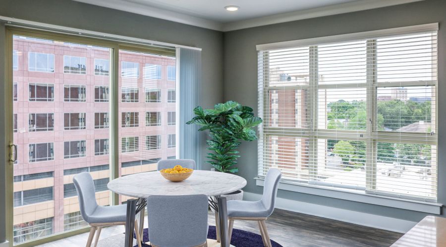 Modern dining area with round table and city view—perfect for your first college apartment at Carolina Square.