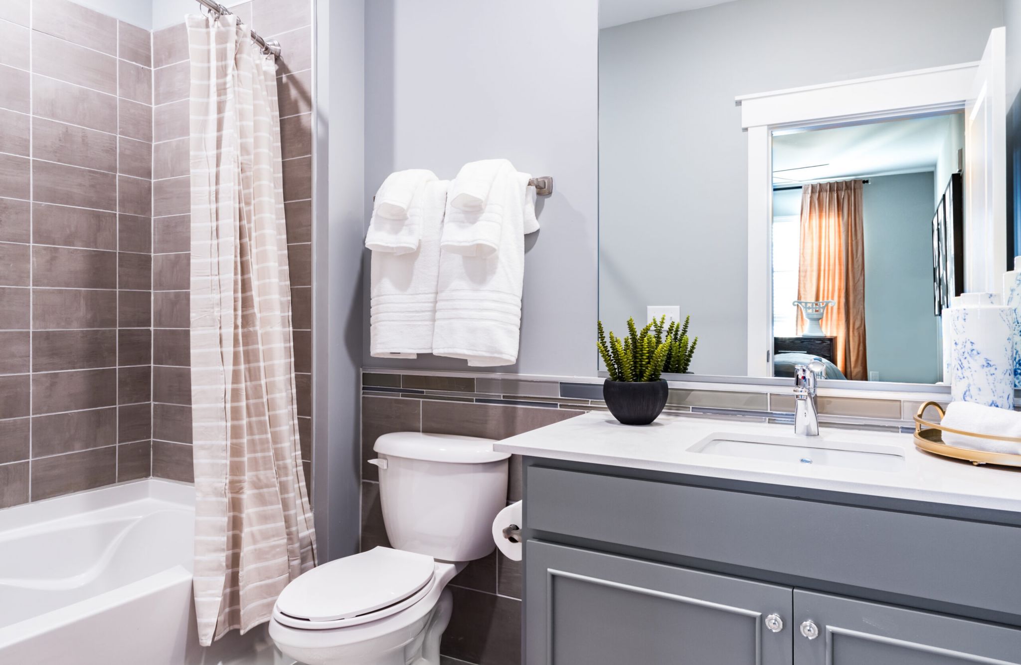 Luxury apartment kitchen with floating kitchen island, pendant lighting, ample cabinet storage, and built-in wine storage