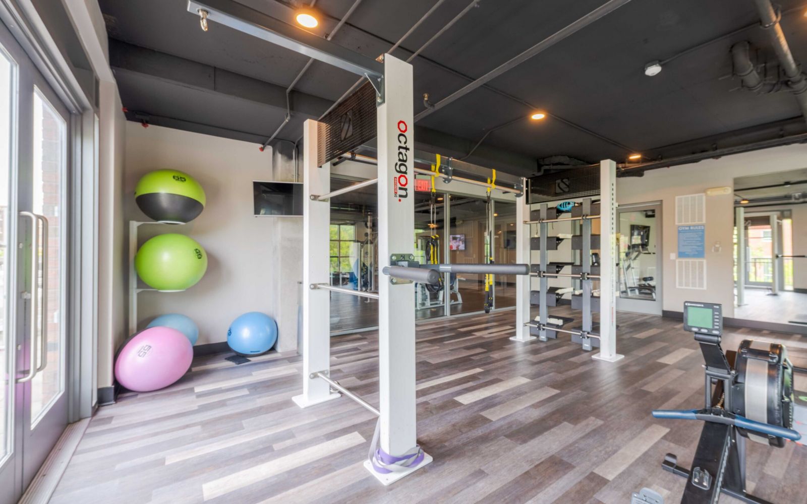 Modern gym at Carolina Square with diverse equipment and stability balls—perfect for your wellness weekend in a bright, airy space.