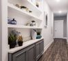Modern hallway with wooden floors, white shelves, potted plants, and decorative vases on built-in cabinetry at Carolina Square apartments