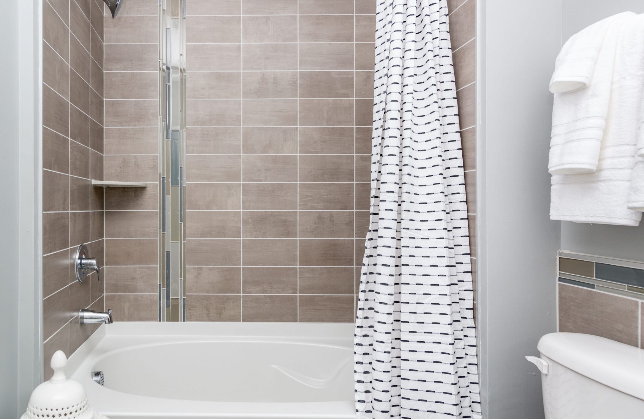 Studio apartment kitchen with stainless steel appliances, built-in wine storage, and small dining table