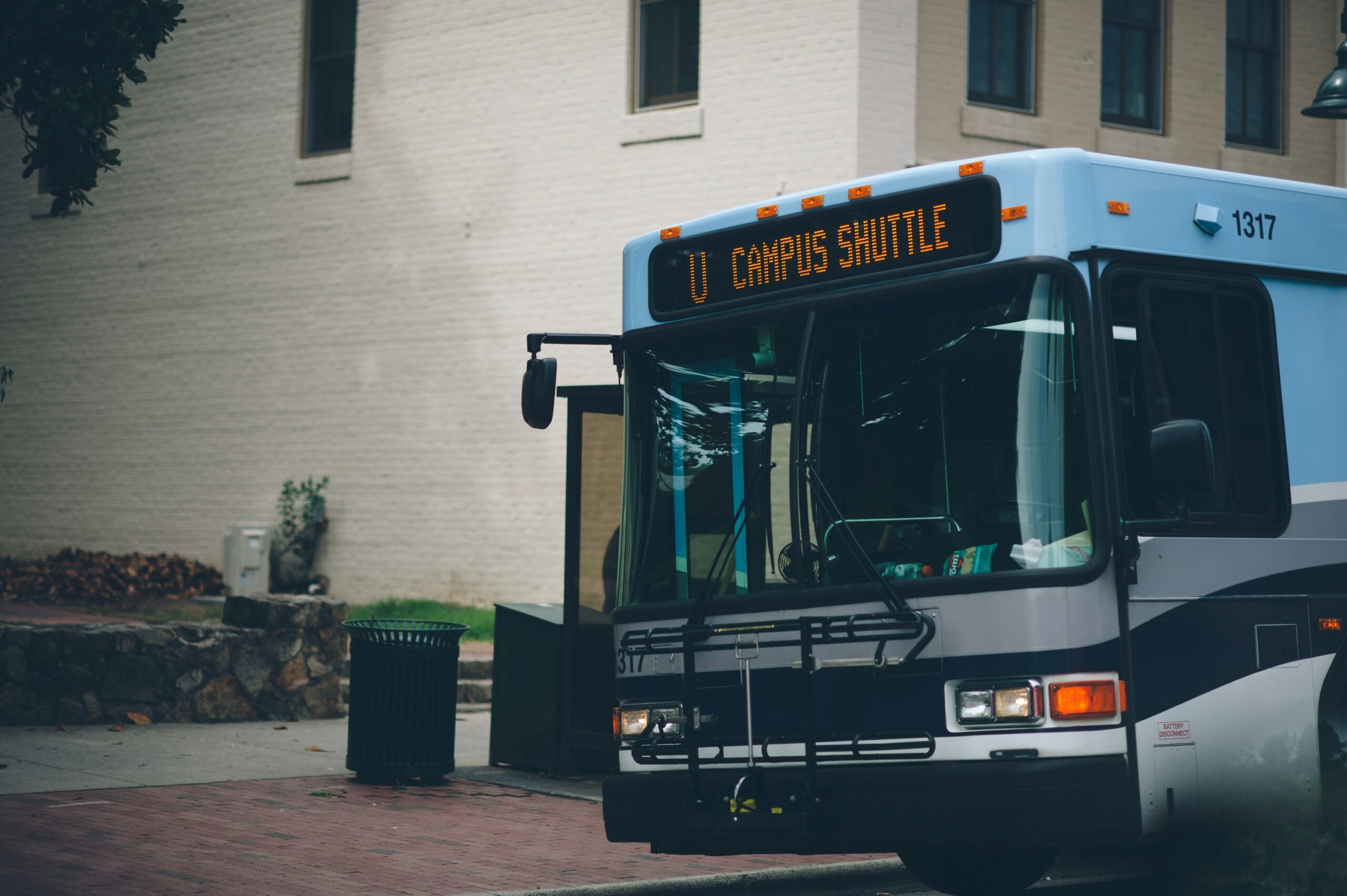 A campus shuttle bus is parked at a stop near Carolina Square, providing easy campus access for UNC students.