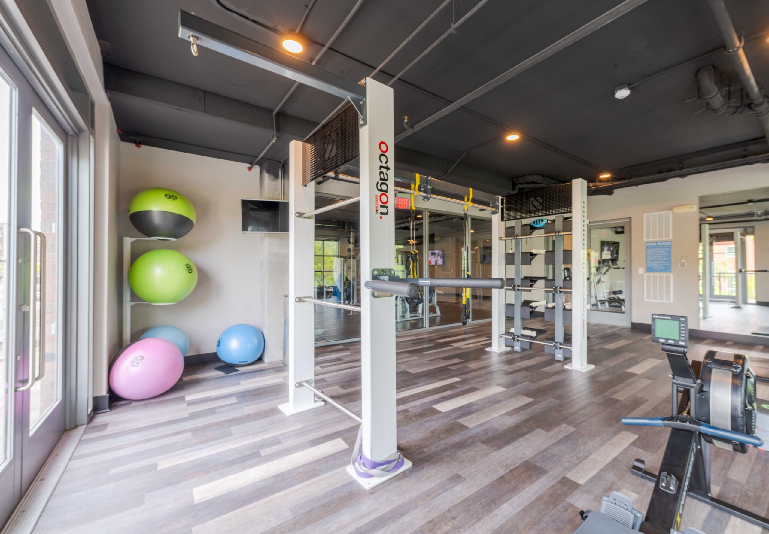 Modern gym at Carolina Square with diverse equipment and stability balls—perfect for your wellness weekend in a bright, airy space.
