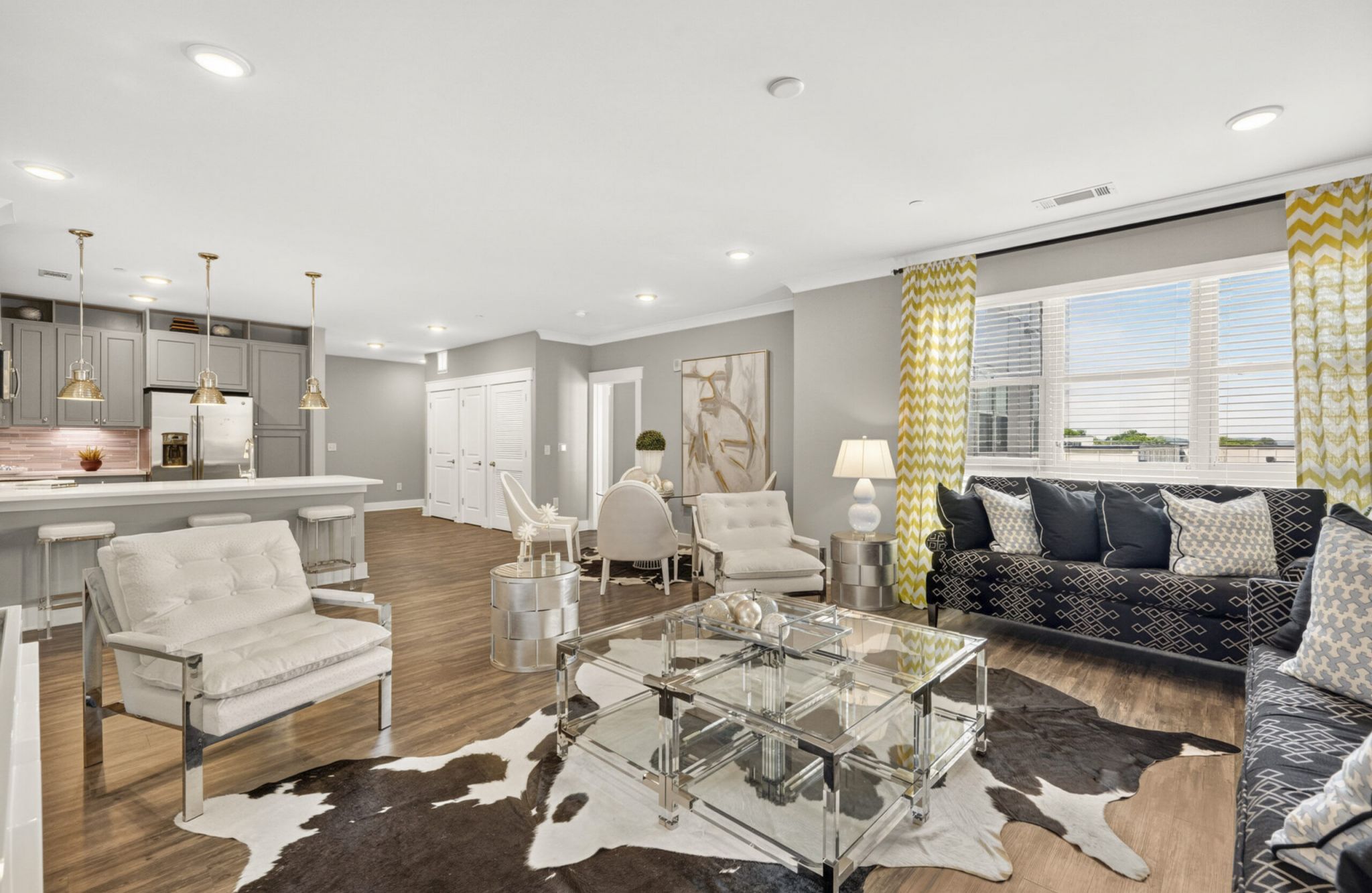 Beautiful apartment living and kitchen area with luxury hard-wood plan flooring, sliding barn doors, and huge windows