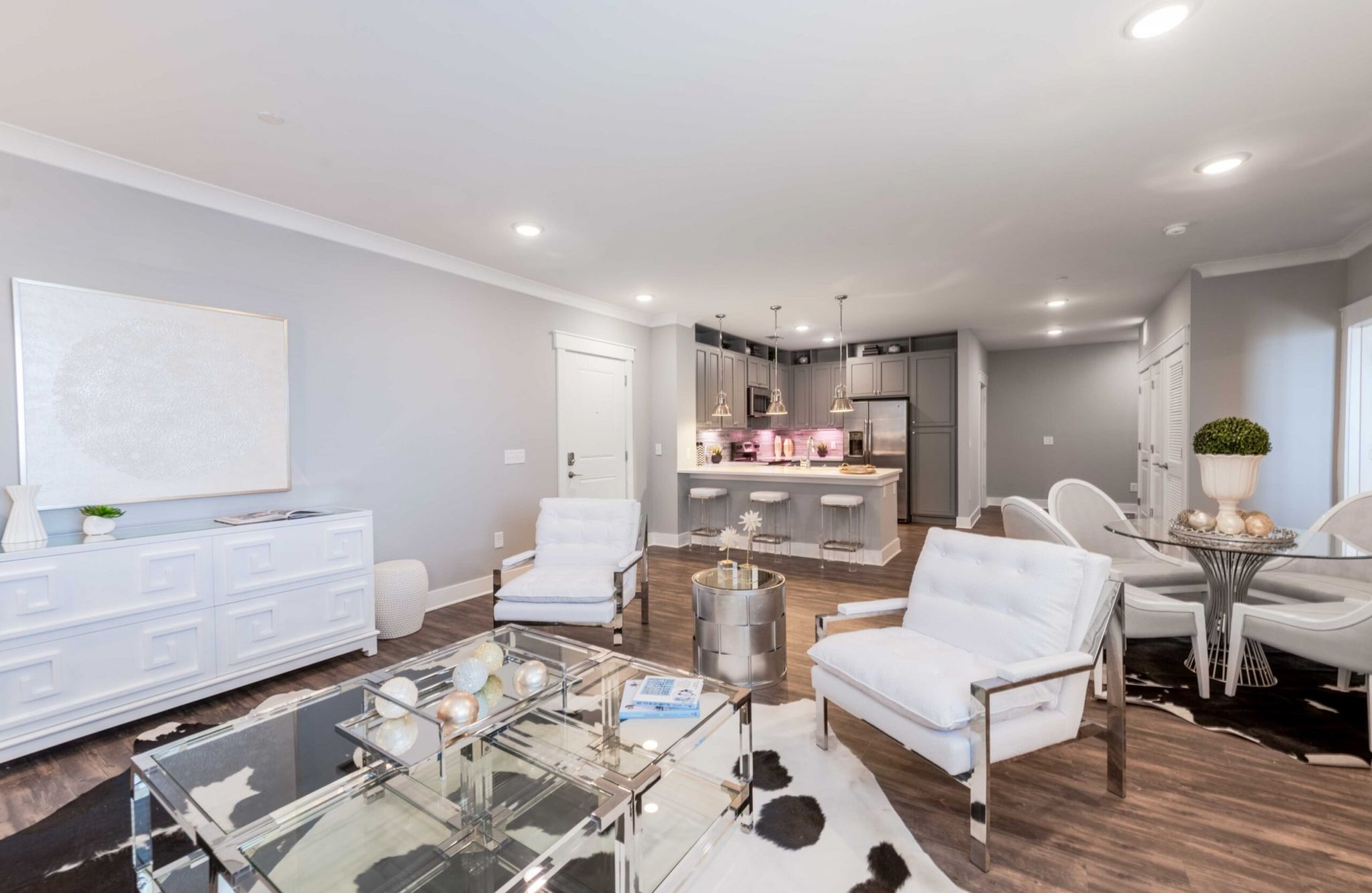 Beautiful apartment living and kitchen area with luxury hard-wood plan flooring, sliding barn doors, and huge windows